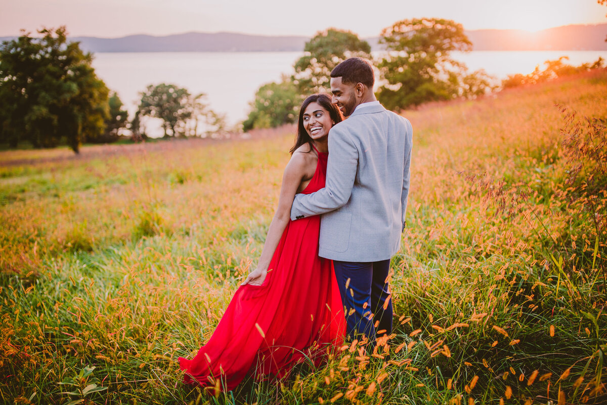 A couple standing on a hall at sunset laughing at rockwood hall ny