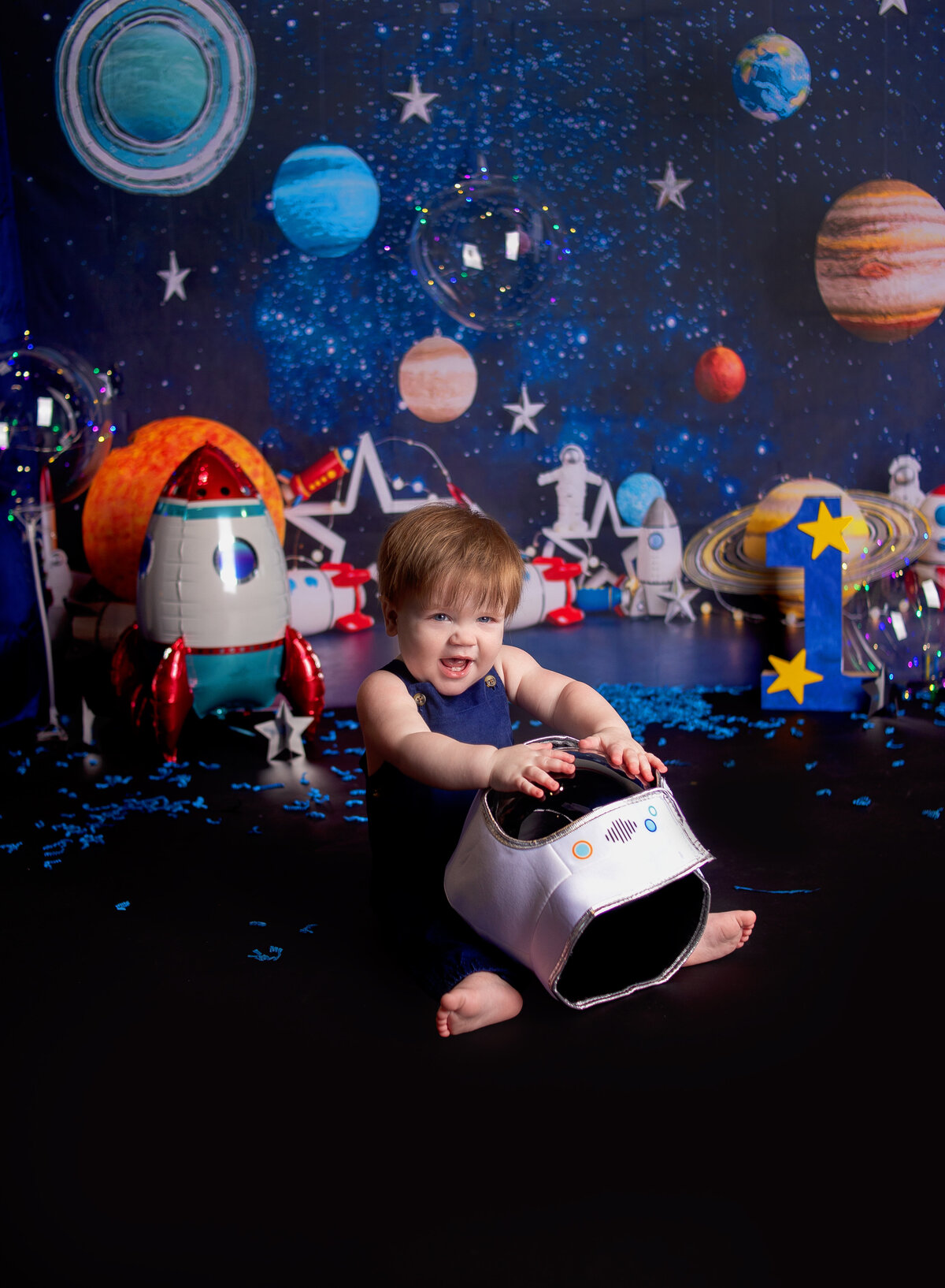 baby boy sitting with space helmet in Franklin TN photography studio with Franklin Tennessee family photographer