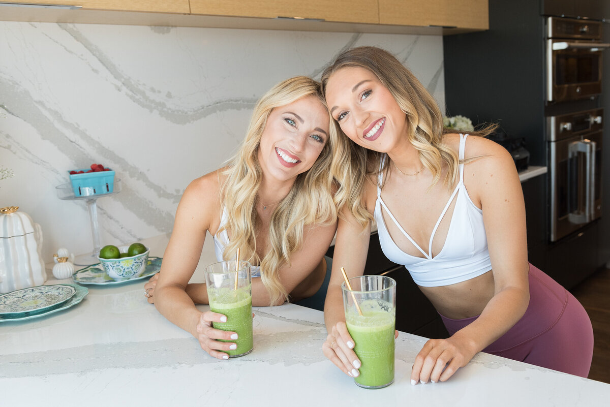 Health-lifestyle-two-women-wearing-athleticwear-holding-smoothies-iowa-kitchen-ivy-towler-photography