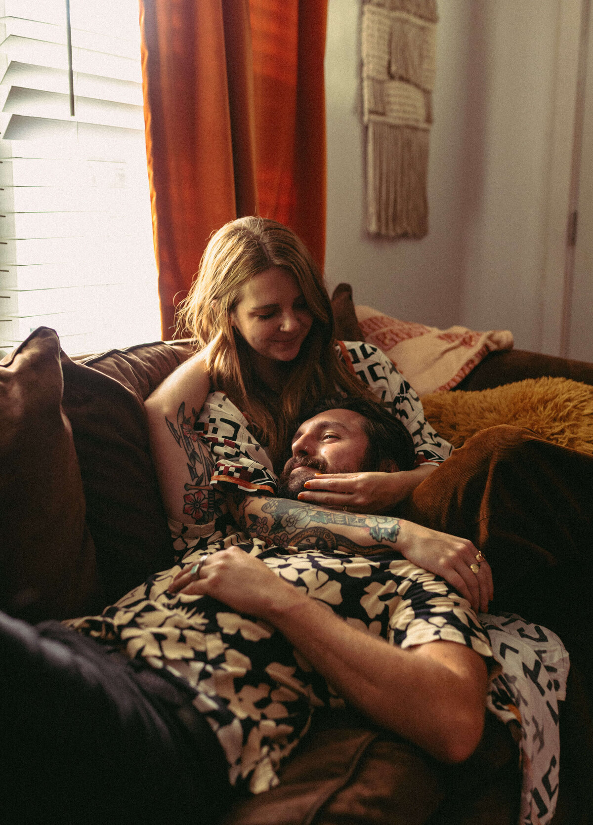 couple cuddles with mans head in womans lap - during in-home engagement session in panama city