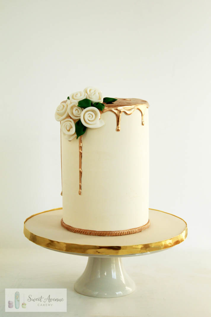 elegant white and gold double barrel cake with flowers