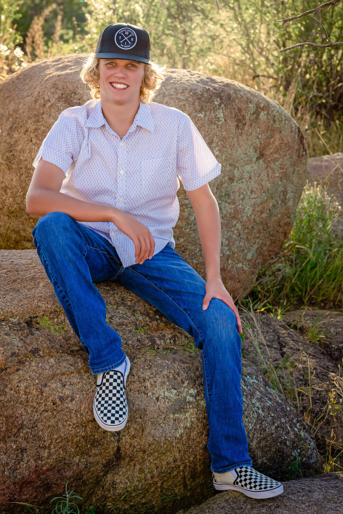 Boy poses on rock in Granite Dells for Prescott senior photography session with Melissa Byrne
