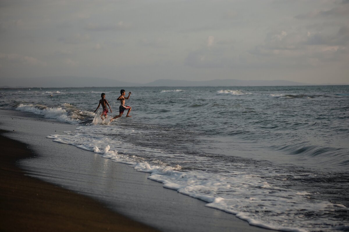 children playing on a beach during an international  family vacation planned by  international travel agent