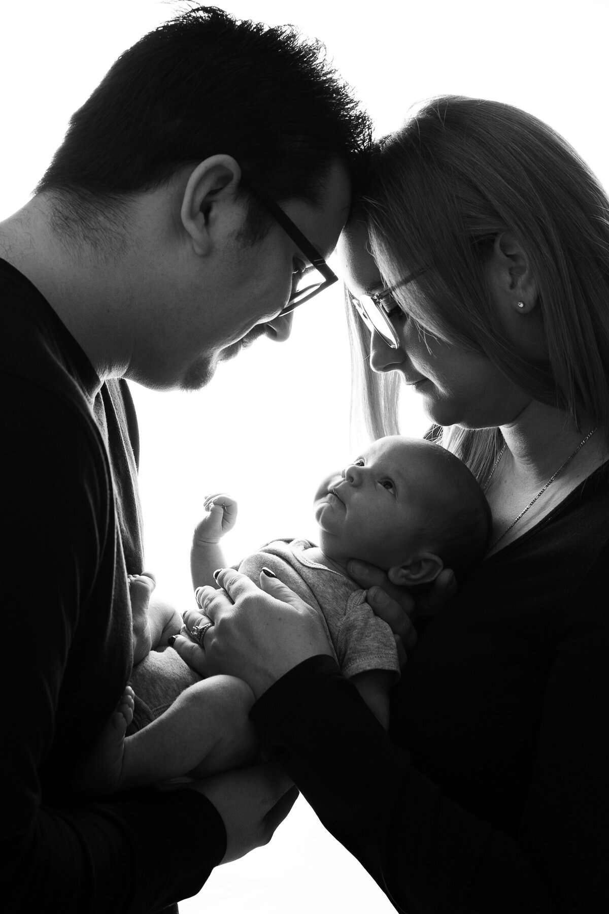 Black and white studio in Paris, Ontario newborn portrait with parents holding baby | Meraki Photographic Creations