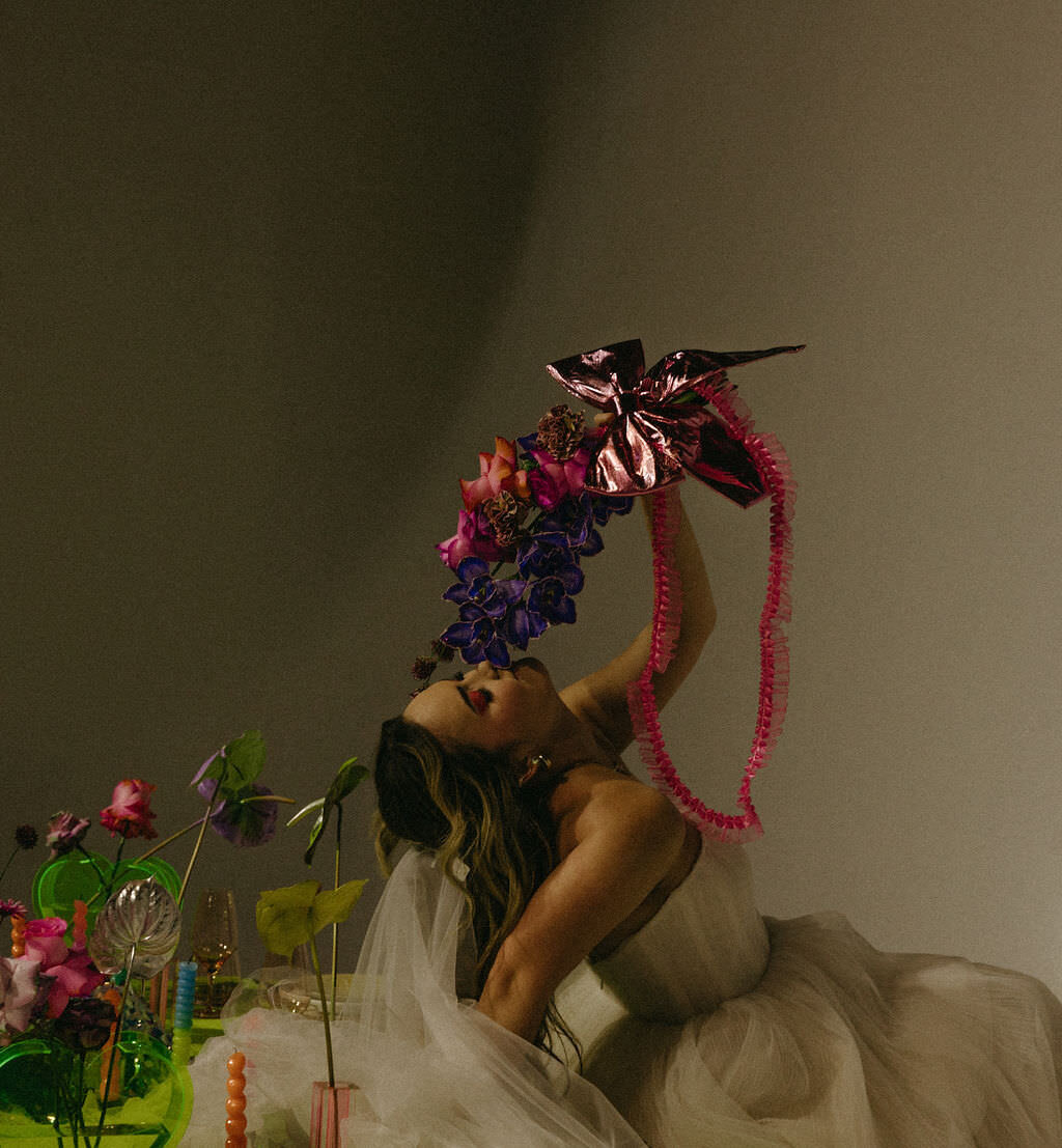 A person in a wedding dress sniffing a bouquet of flowers.