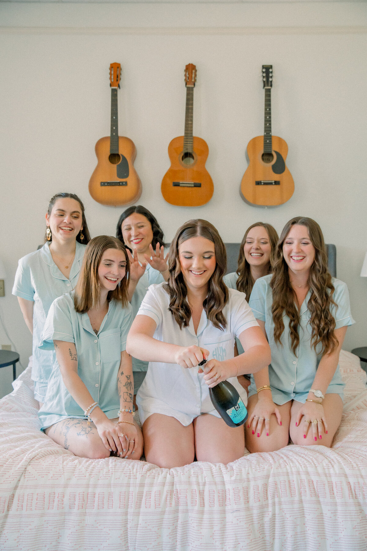 Three Oaks Manor Wedding | bride pops champagne surrounded by bridemaids