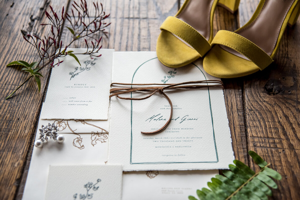 Flat lay of elegant wedding invitation and yellow bridal heels