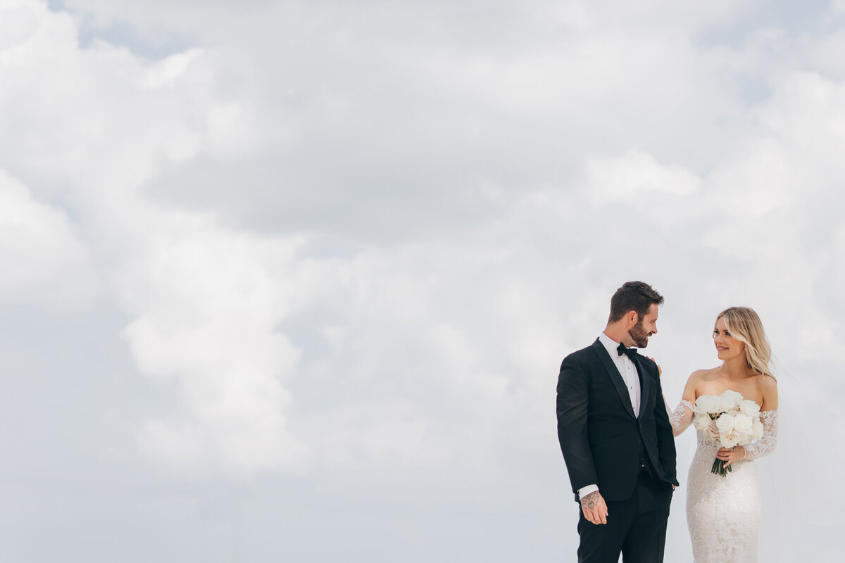 Enchanting bride and groom first look with beautiful cloudy background