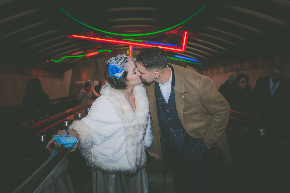 Bride and groom kiss on escalator in Jersey City.
