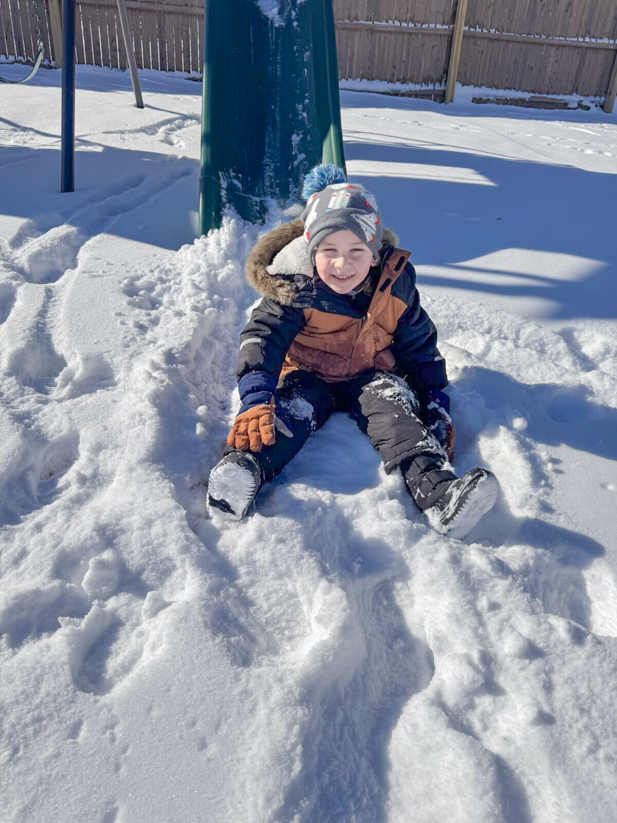 Child playing in the snow at House of Parker Preschool in Gorham Maine where the magic of play helps our students grow, learn, and thrive, making every moment a joyful step in their development.