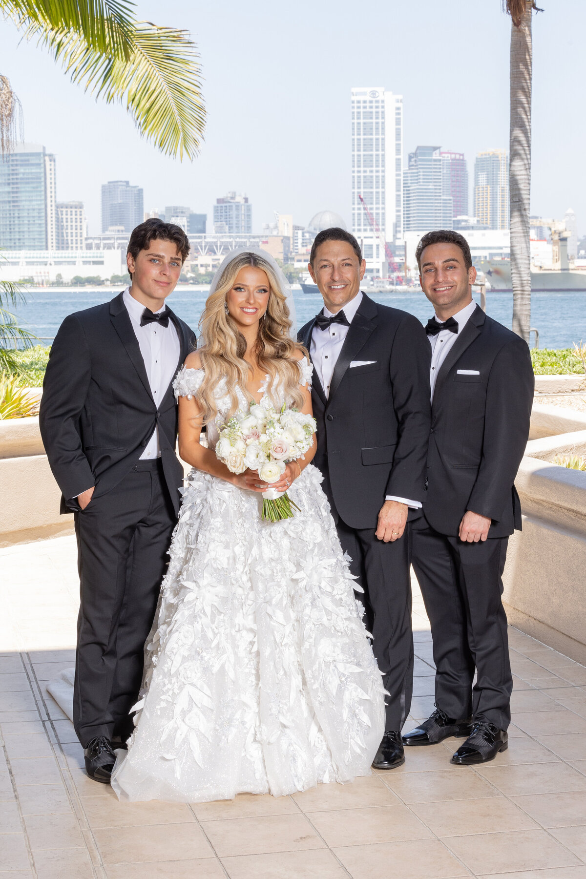 A bride smiling with three wedding guests