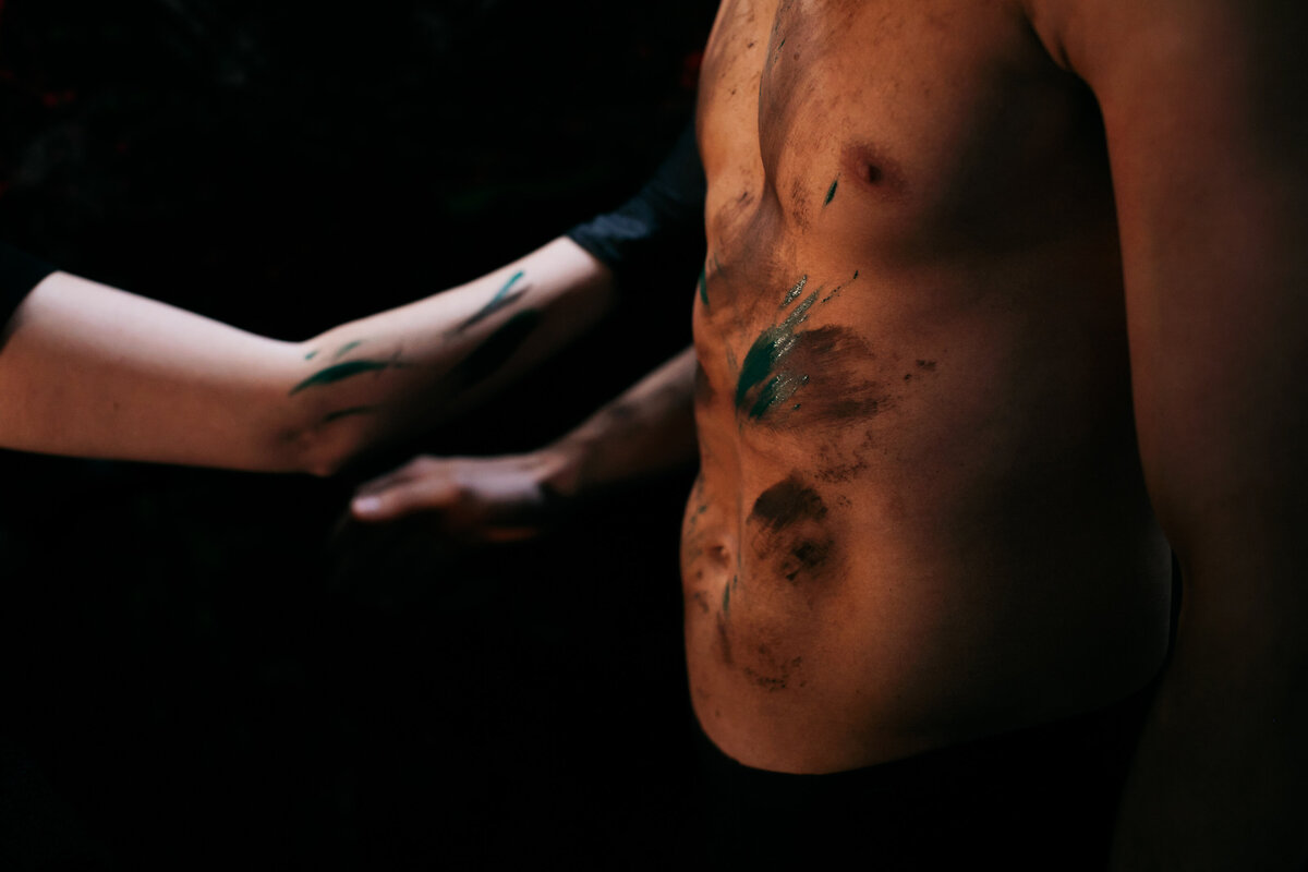 Backstage portret van acteur die in de grime wordt gezet door make-up artiest.