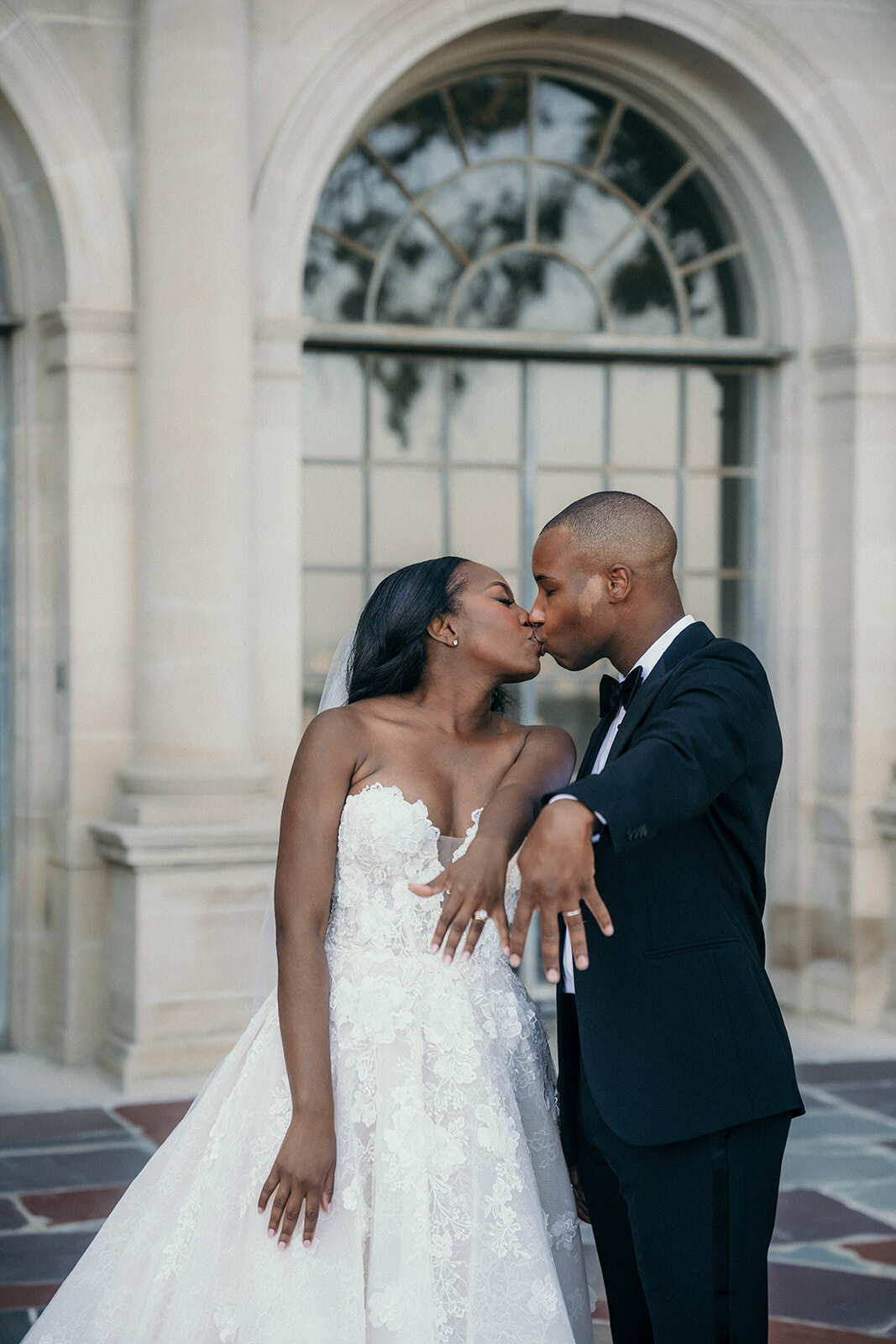 Newly weds show their wedding rings and kiss.
