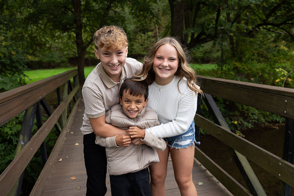 Siblingshugingonabridgeattheuniversityofpittsburghcampus.