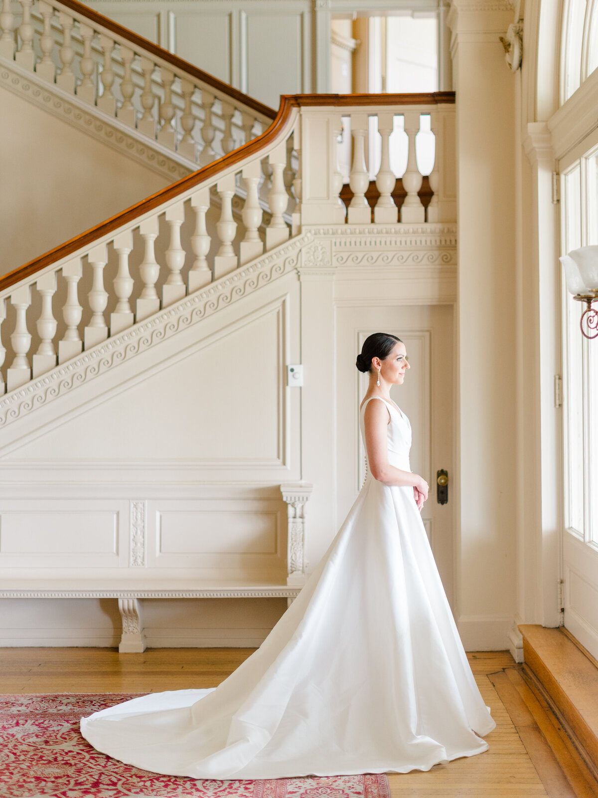 Elegant bridal portrait at Cairnwood Estate featuring a classic A-line wedding gown with a dramatic train, captured by Philadelphia Fine Art Wedding Photographer Elizabeth Kane. This image highlights refined East Coast wedding style, natural light, and timeless luxury within a historic Gilded Age setting.