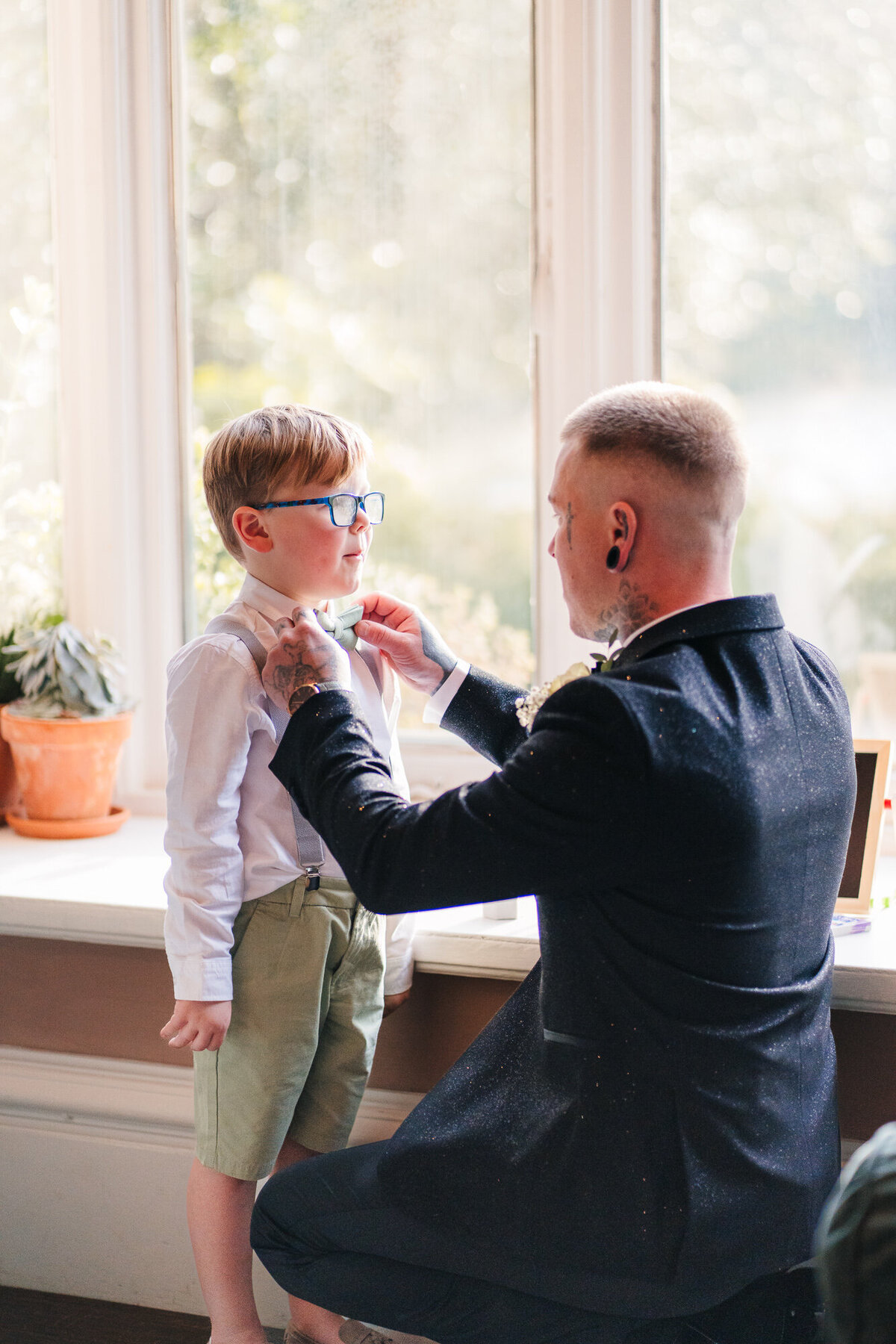Groom fixing his son's bow tie at Ashfiled House takne by documentary wedding photographer  Anthony Horseman
