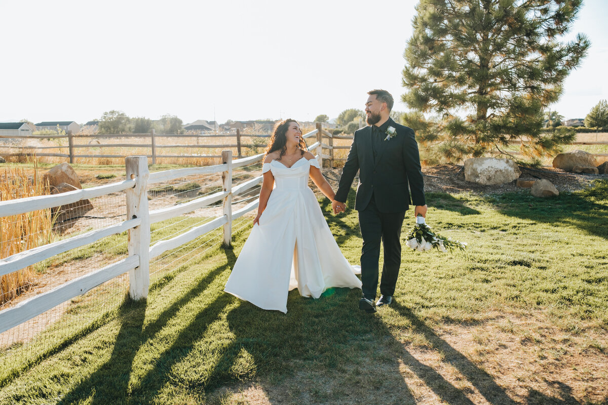 Couple walking hand in hand along the fence line