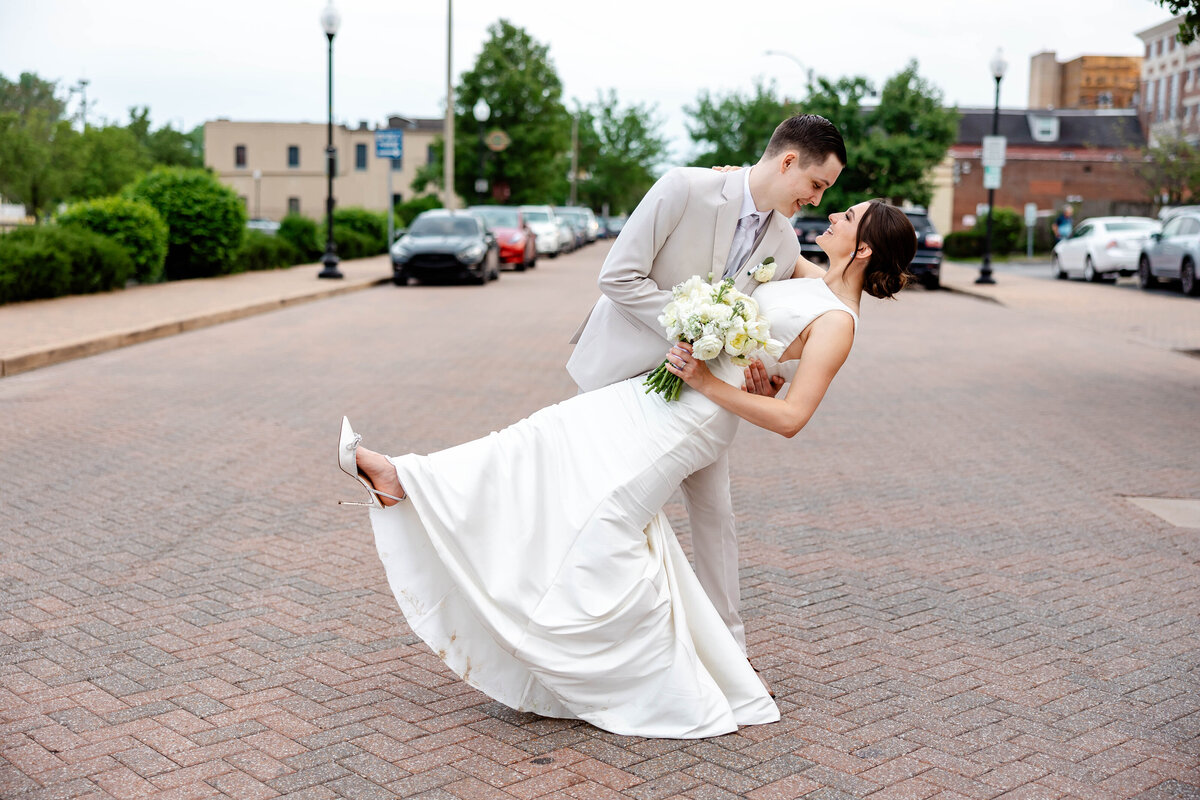 Romantic couples portraits captured by Style & Grace Photography on Main Street in St. Charles, MO, showcasing the couple’s love amidst charming city streets on their wedding day.