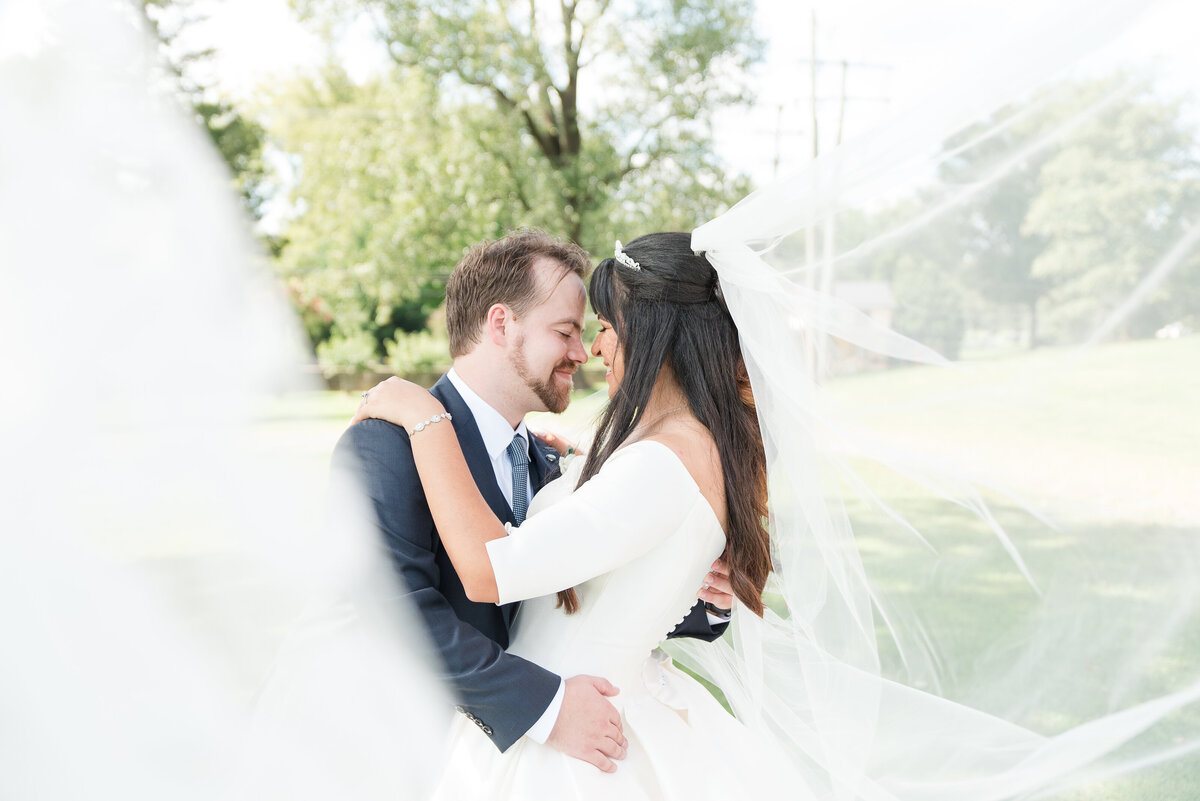 couple kissing surrounded by veil
