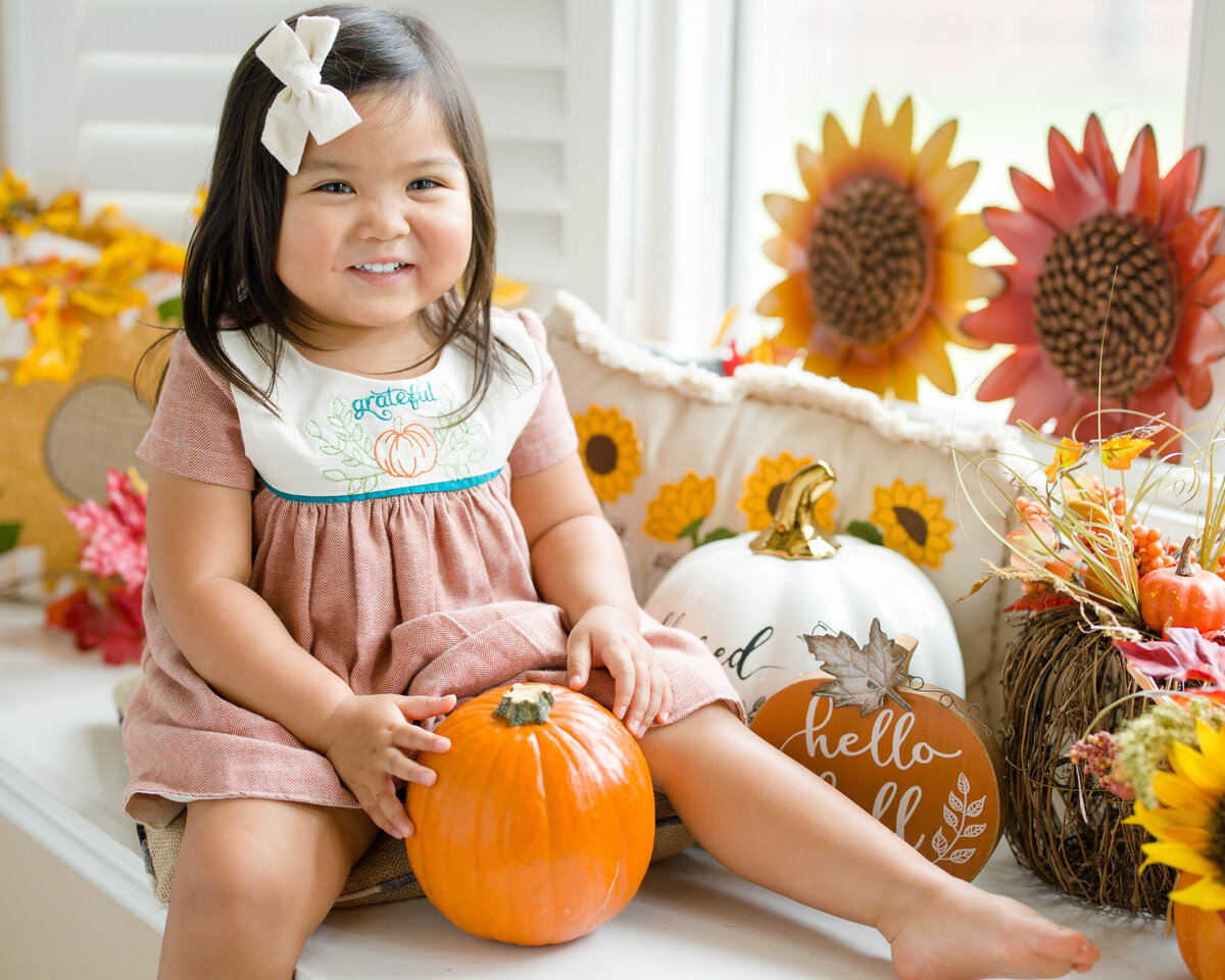 Fall photo with pumpkin of little girlby Lucas Mason Photography in Orlando, Windermere, Winder Garden area
