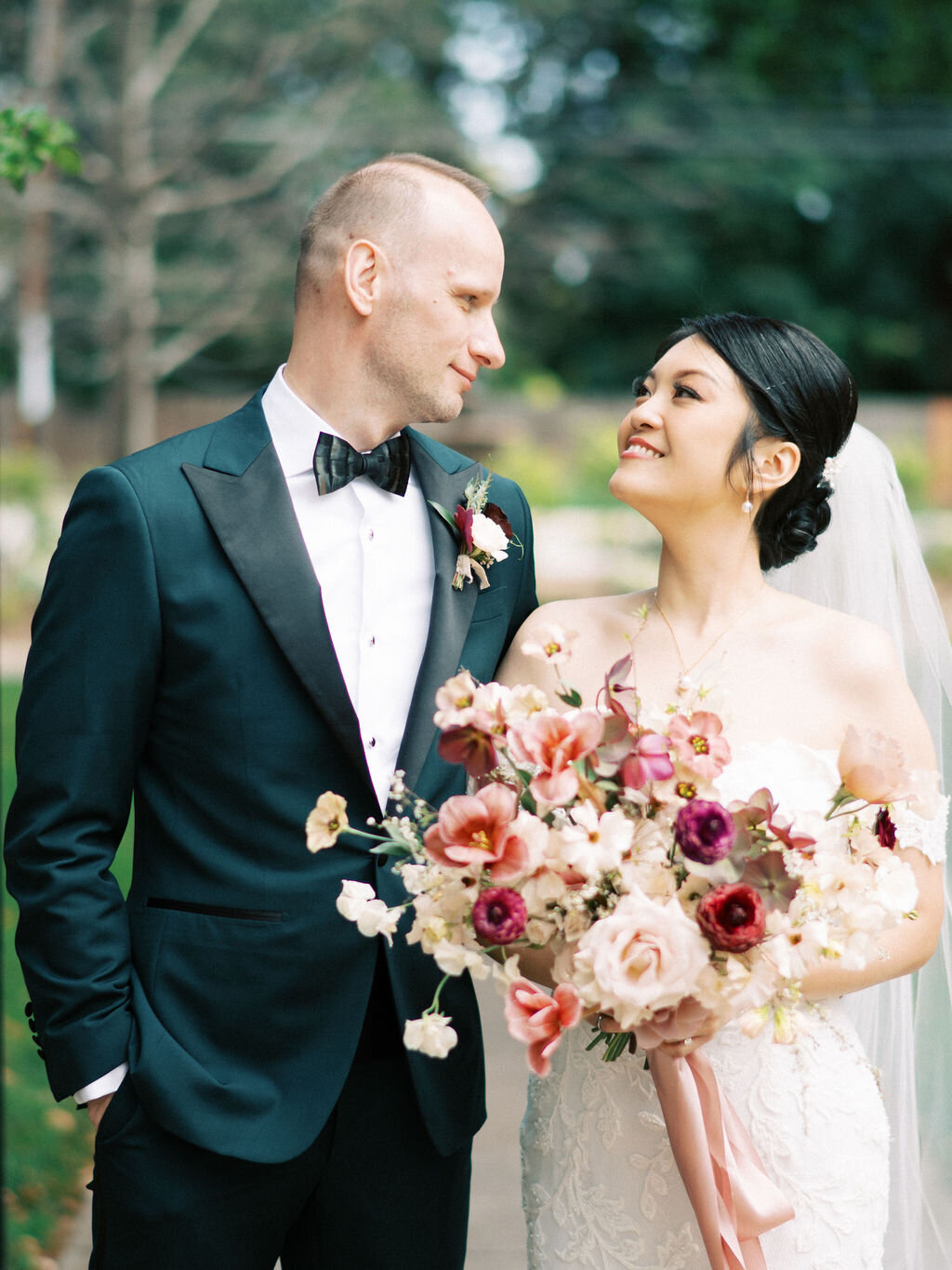 dusty rose bridal bouquet held by bride looking up at groom with boutonniere at palo alto church venue