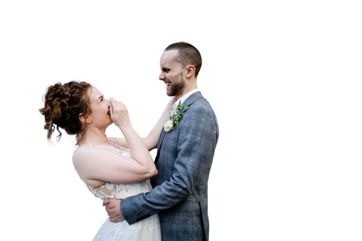 a couple looking at each other in fun photograph, the bride is laughing with her hand over her mouth outside the paintworks in bristol.