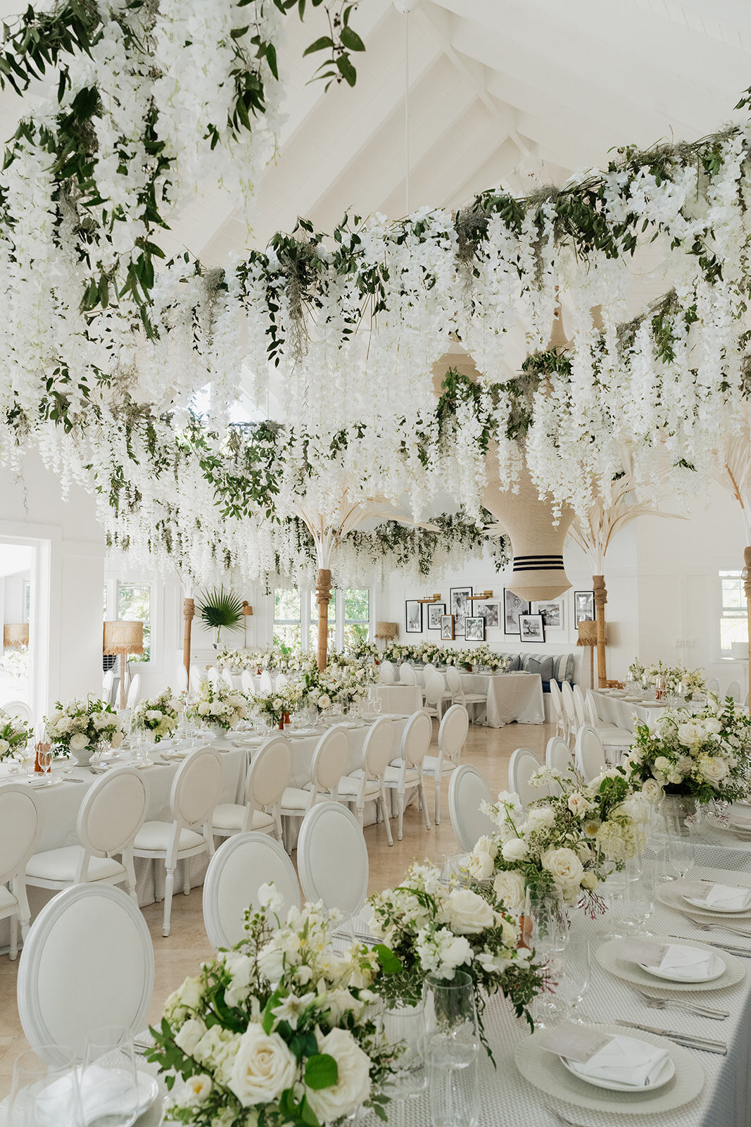 Elegant and timeless white floral wedding in the Bahamas. Wedding reception with lush tables and a ceiling floral installation. Island destination wedding floral design for spring wedding. Design by Rosemary & Finch Floral Design in Nashville, TN.