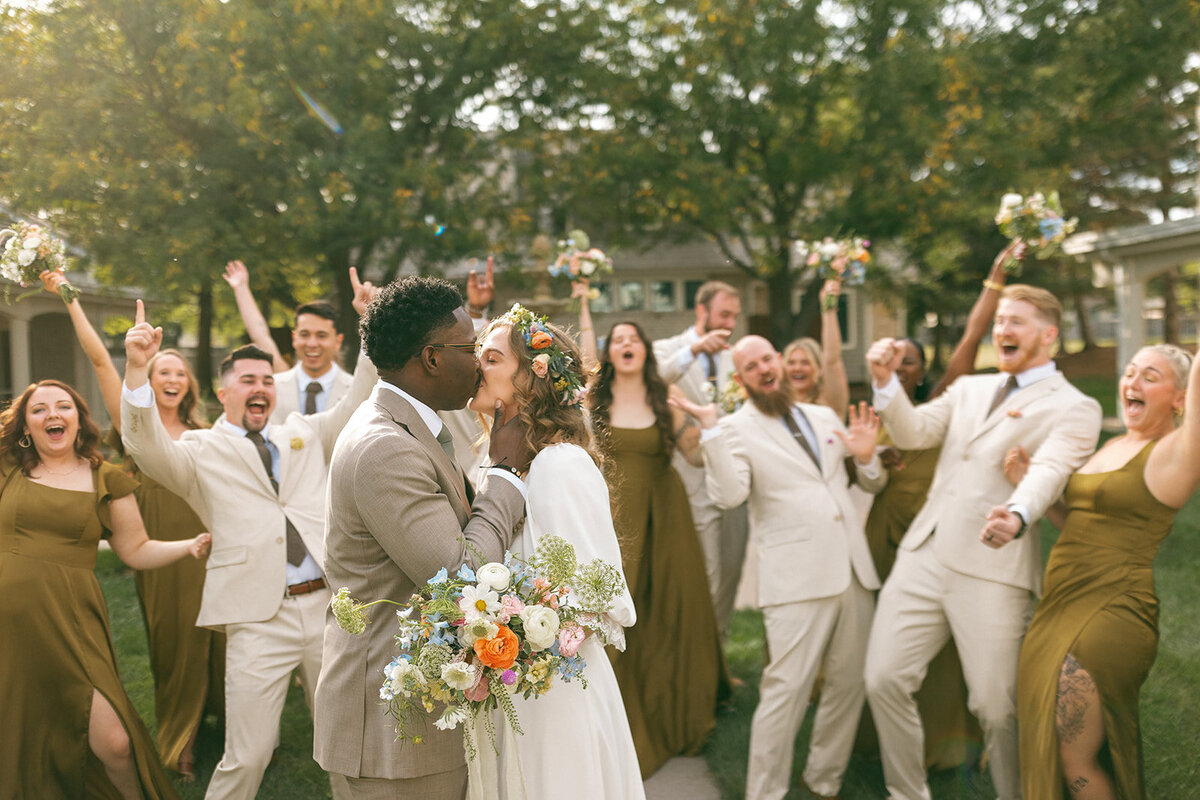 cute-groom-kissing-bride-with-wedding-party-kate-torline-portrait-wedding-photography-kansas-city