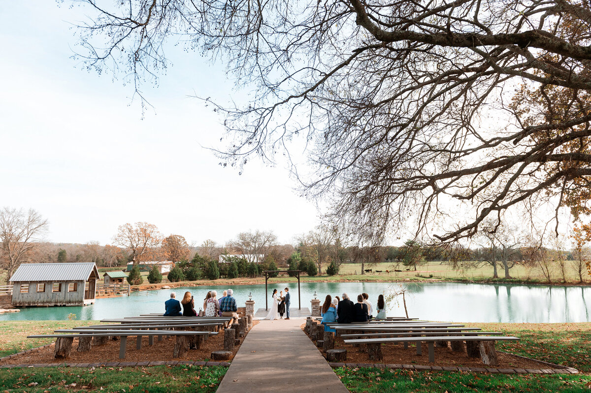 Fall elopement at steel magnolia barn during the ceremony with pond