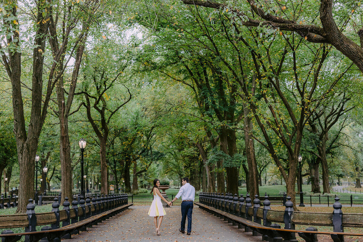 The engaged couple is walking in the beautiful Central Park during fall. Image by Jenny Fu Studio.