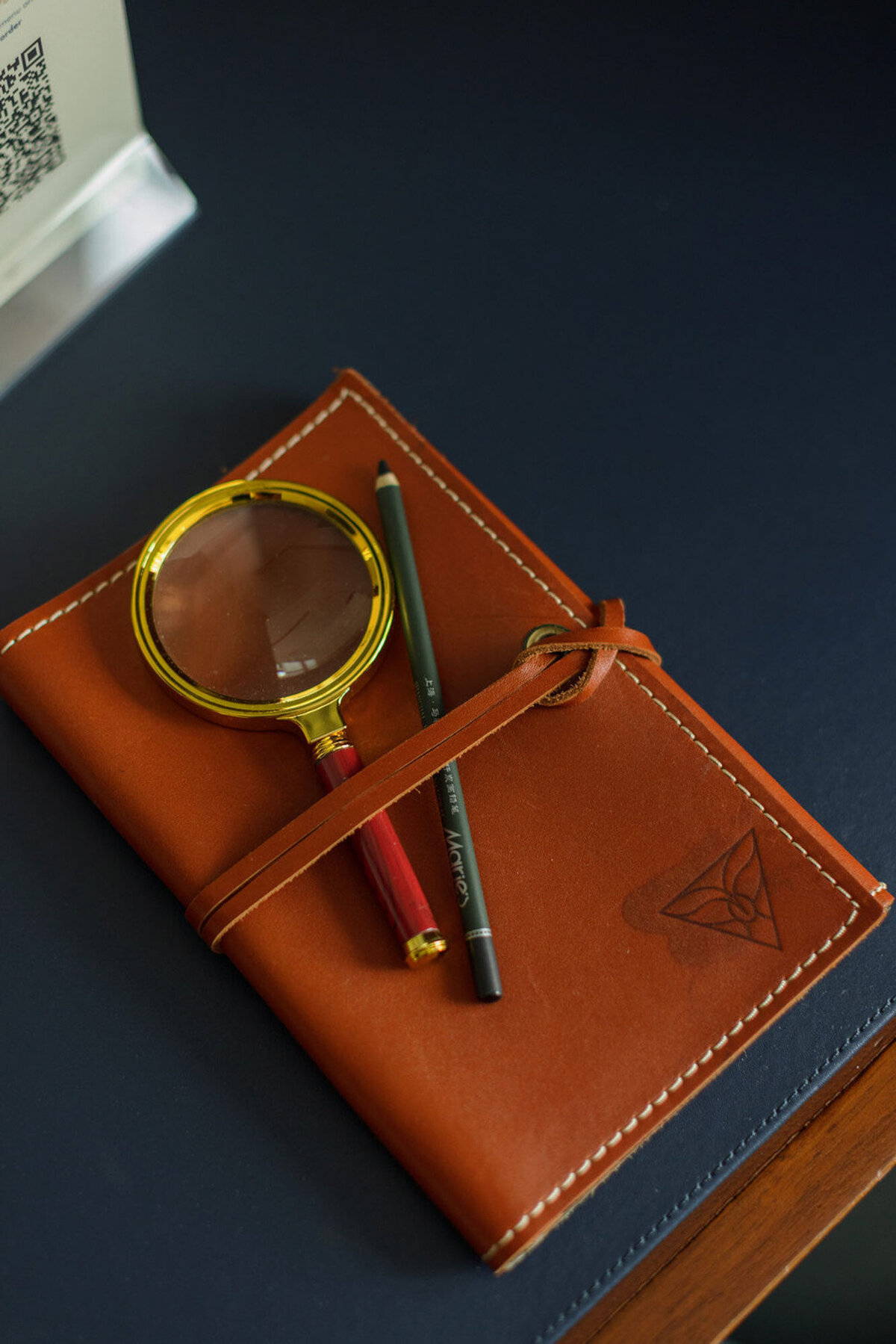 leather journal with magnifying glass and pencil