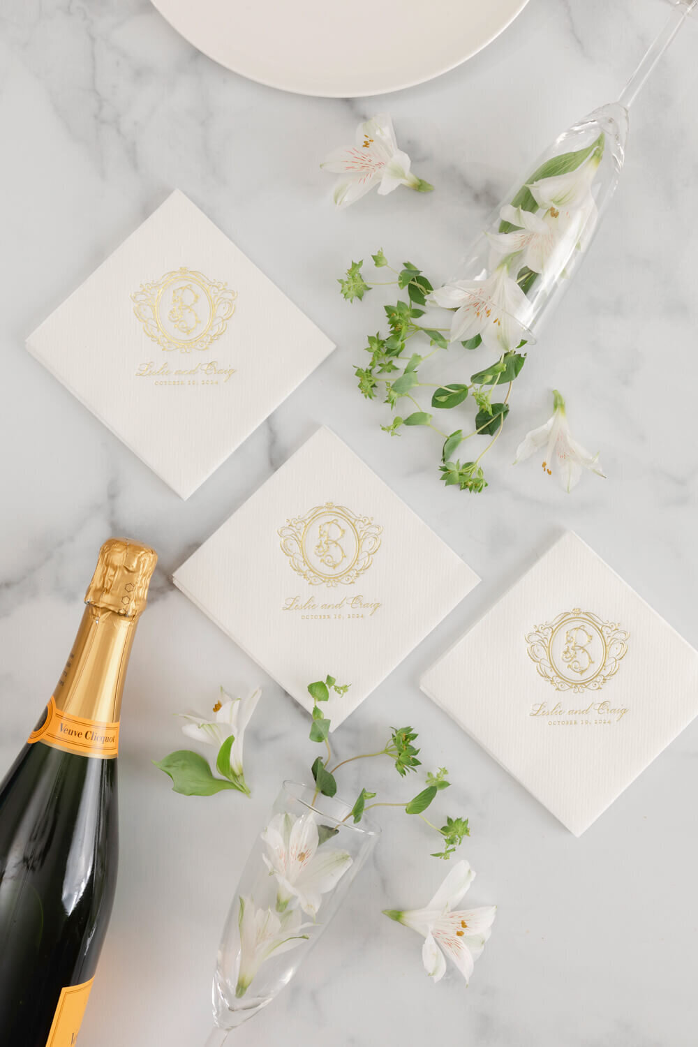 Custom white cocktail napkins with gold foil monogram and wedding date for a luxury wedding celebration.