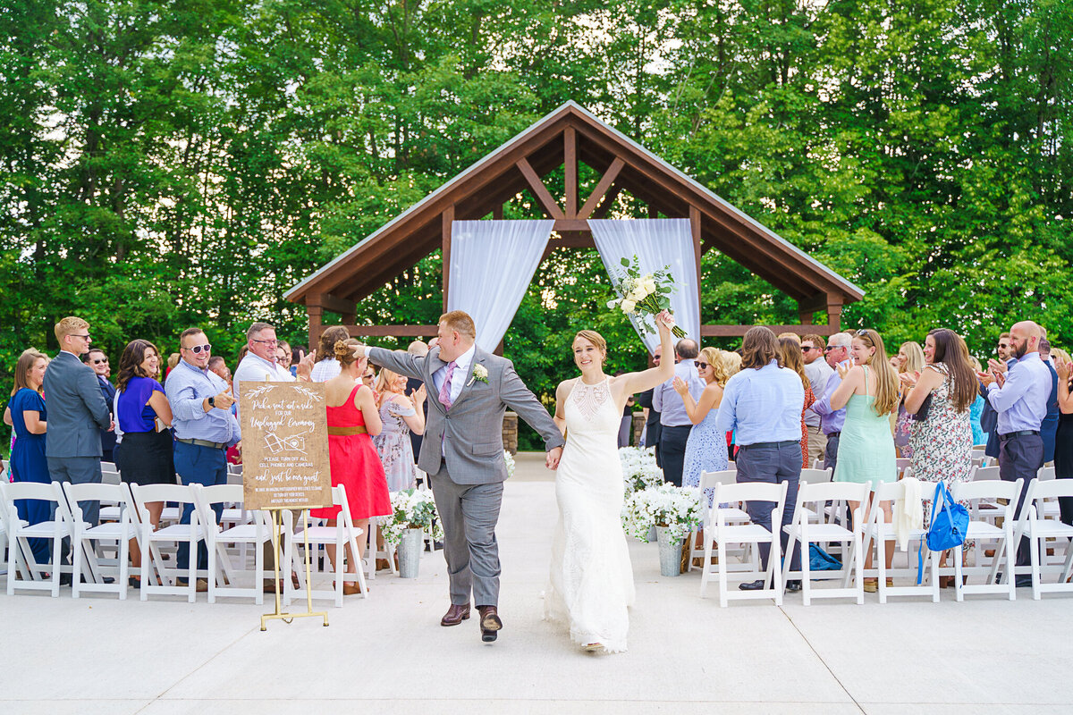 Bride and groom, Liz and Matt cheer as their guests applaud them after their wedding ceremony at Four Seasons Barn in Cardington, Ohio.