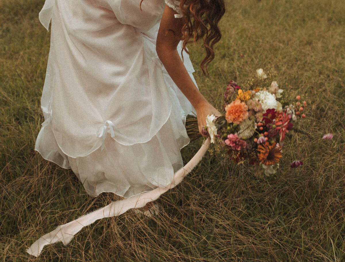 Bride picking up her florals on her wedding day during bridal portraits