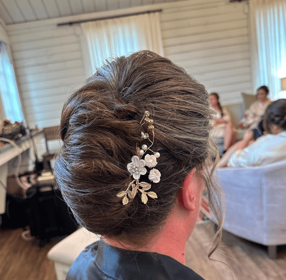 French twist wedding updo with floral hairpiece styled by wedding hairdresser in San Antonio