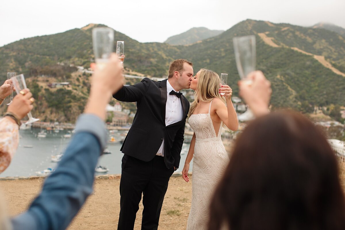 A bride and groom hold up their champagne glasses for a toast