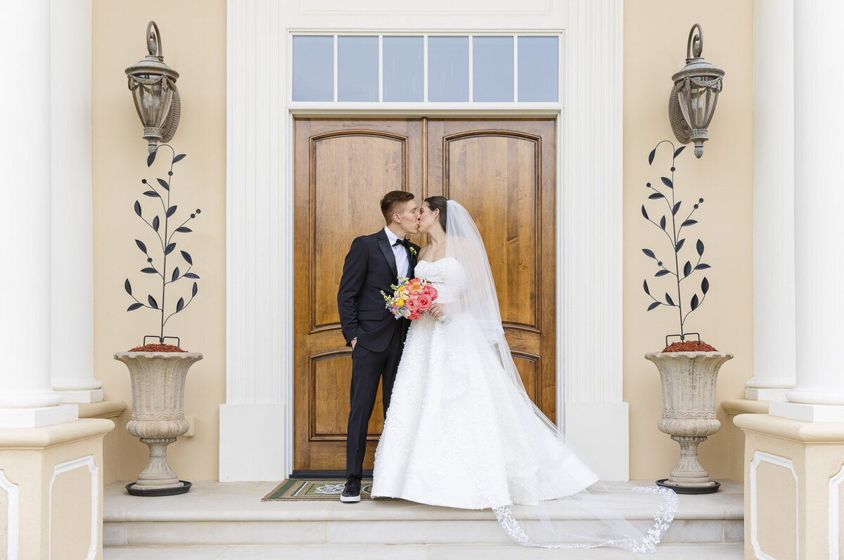 bride and groom kissing outside a catholic church