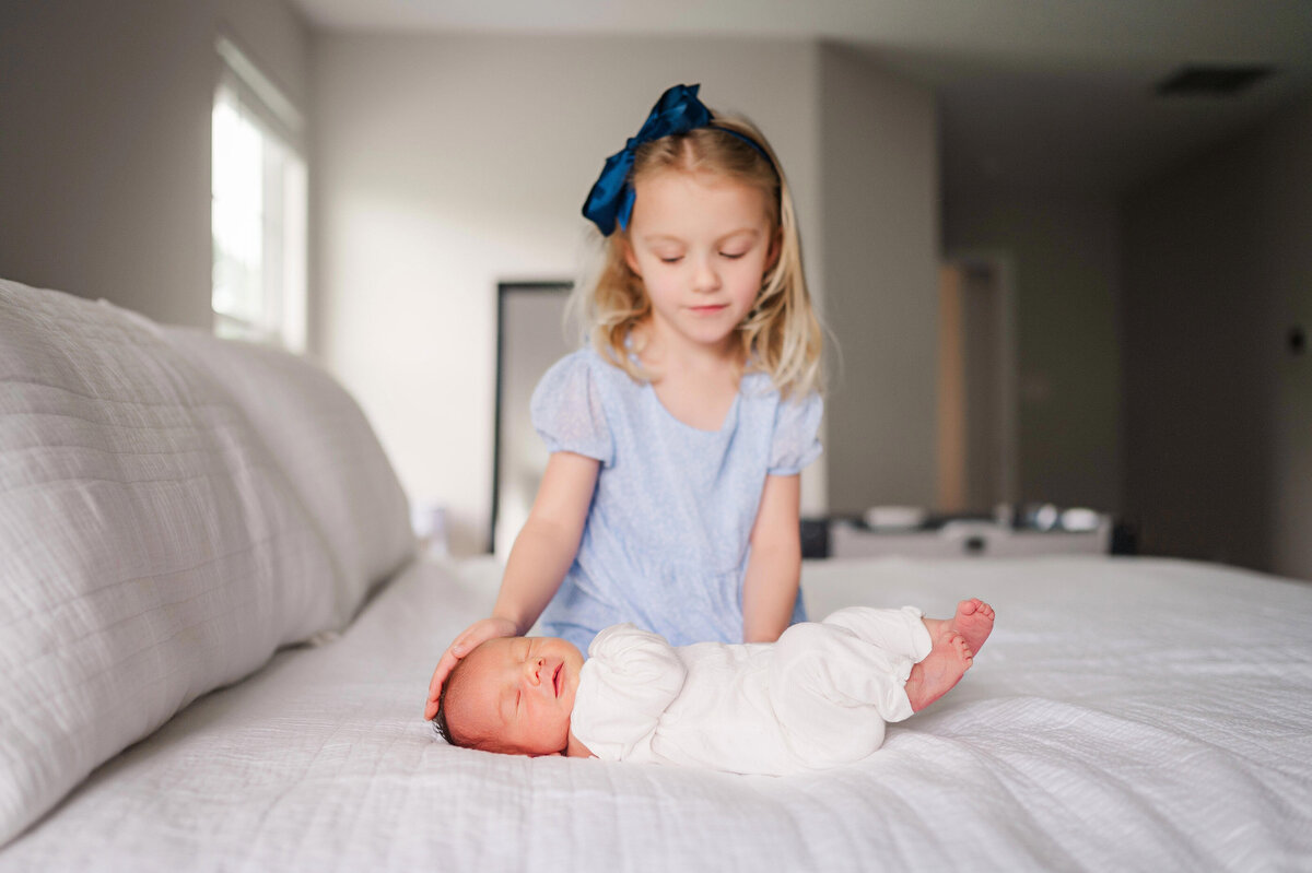 sister snuggling with baby brother during in home newborn photo session pittsburgh peters township