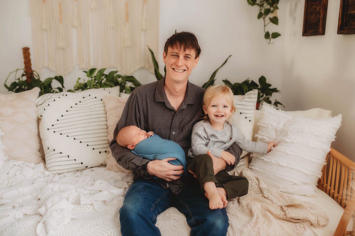 Father embraces his sons during Newborn Photoshoot in Charleston.