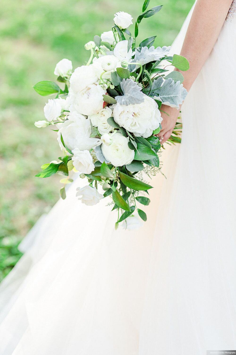 Close-up of a white bridal bouquet with green foliage