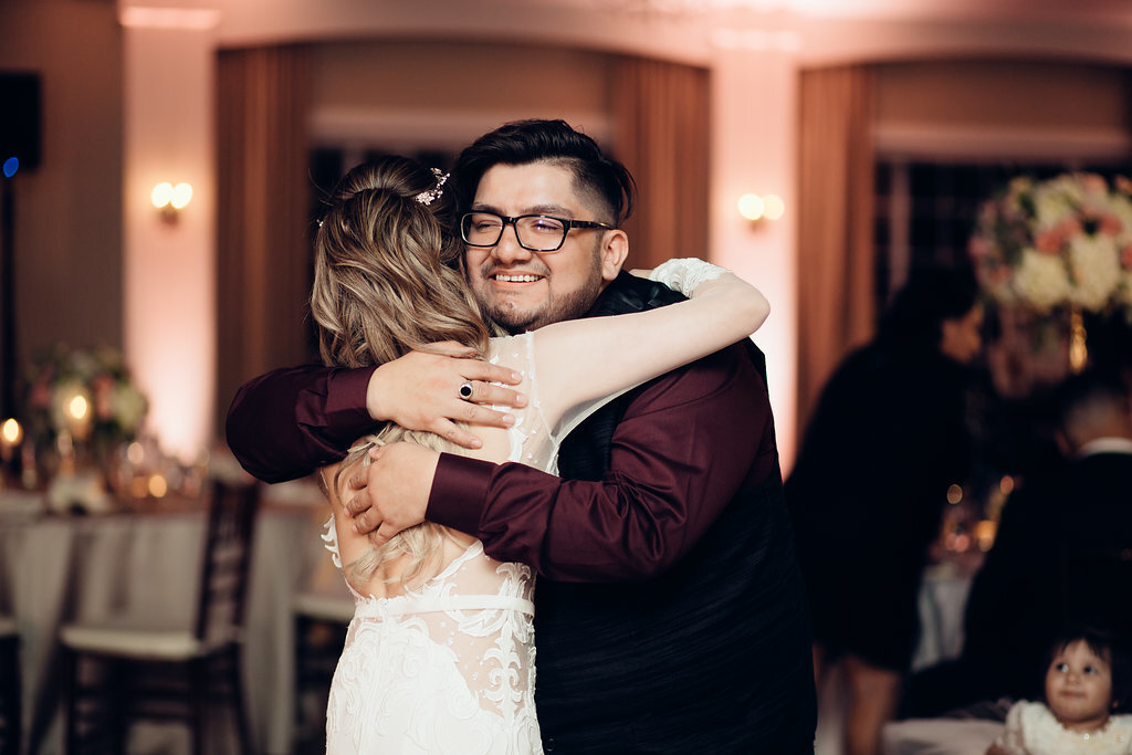 Wedding Photograph Of Man In Black And Maroon Suit Smiling While Hugging The Bride Los Angeles