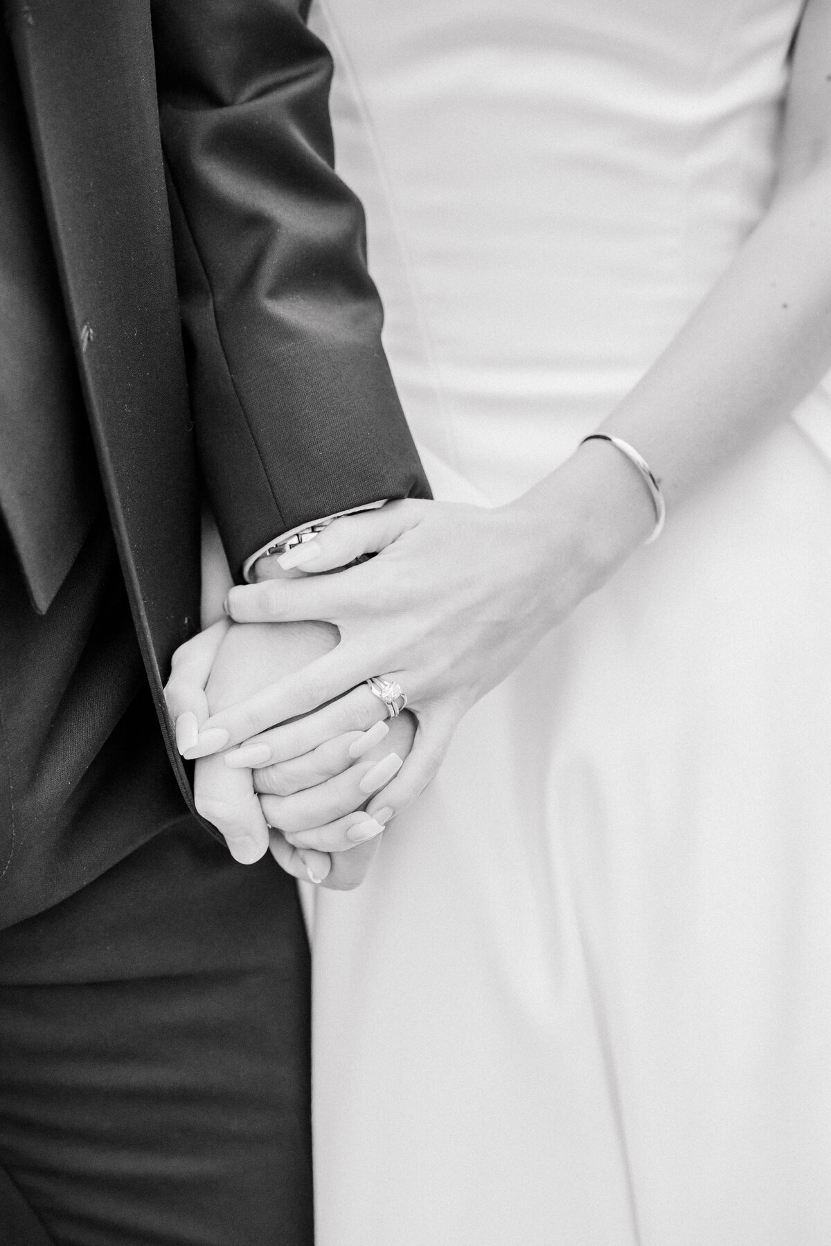 Bride and groom holding hands in black and white