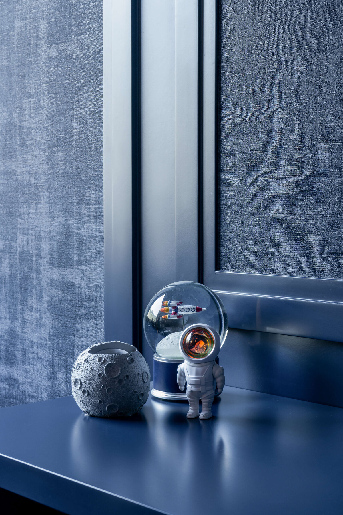 Space-themed trinkets in a boy's blue outer space themed room.