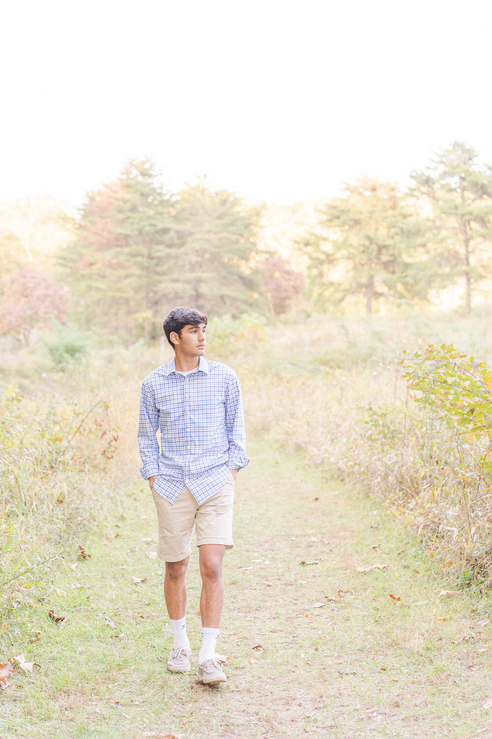 high school boy walking in a field during Fairfax County, VA senior pictures