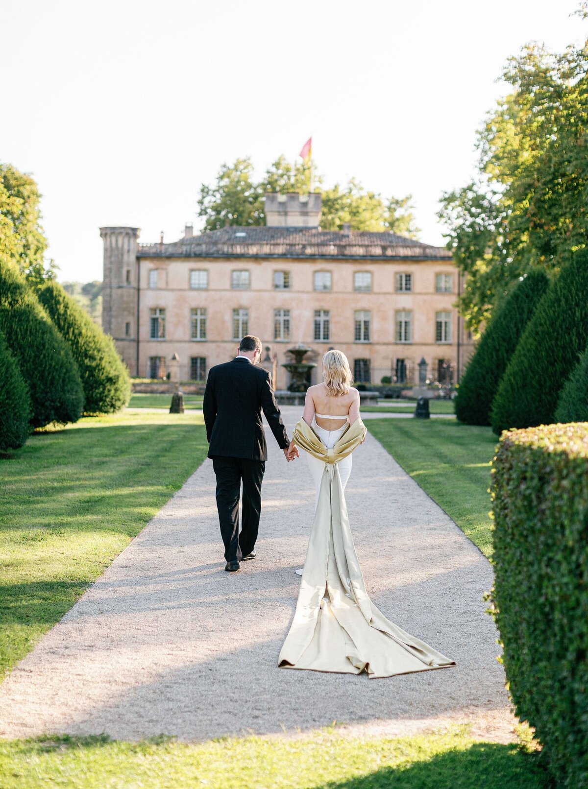 Bride-groom-walking-up-aisle-chateau-gardens
