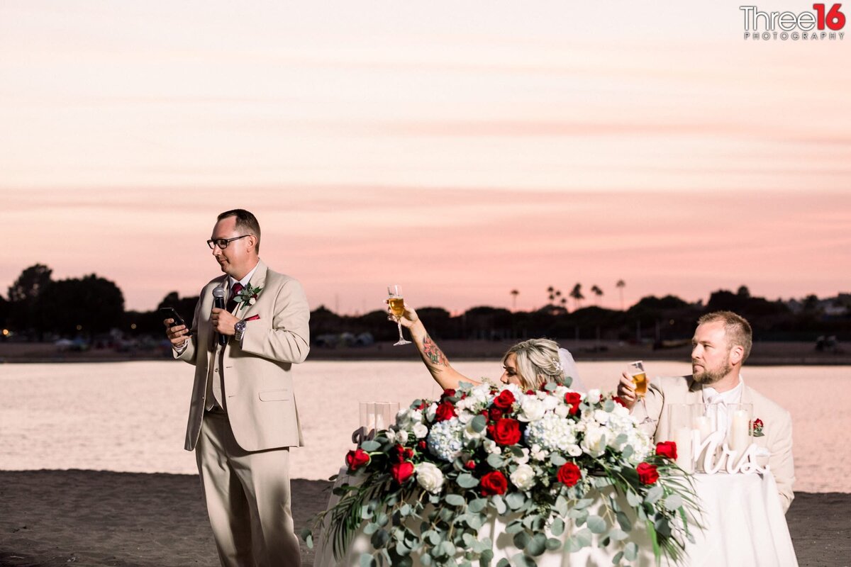 Bride and Groom lift their glasses in toast after the best man's speech