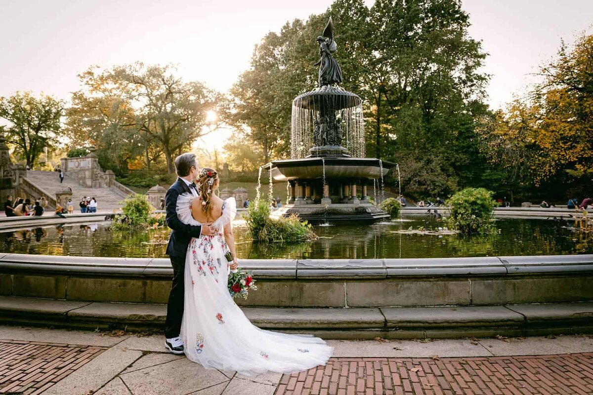 A couple watch the sun set the the Bethesda terrace  fountain on their wedding day
