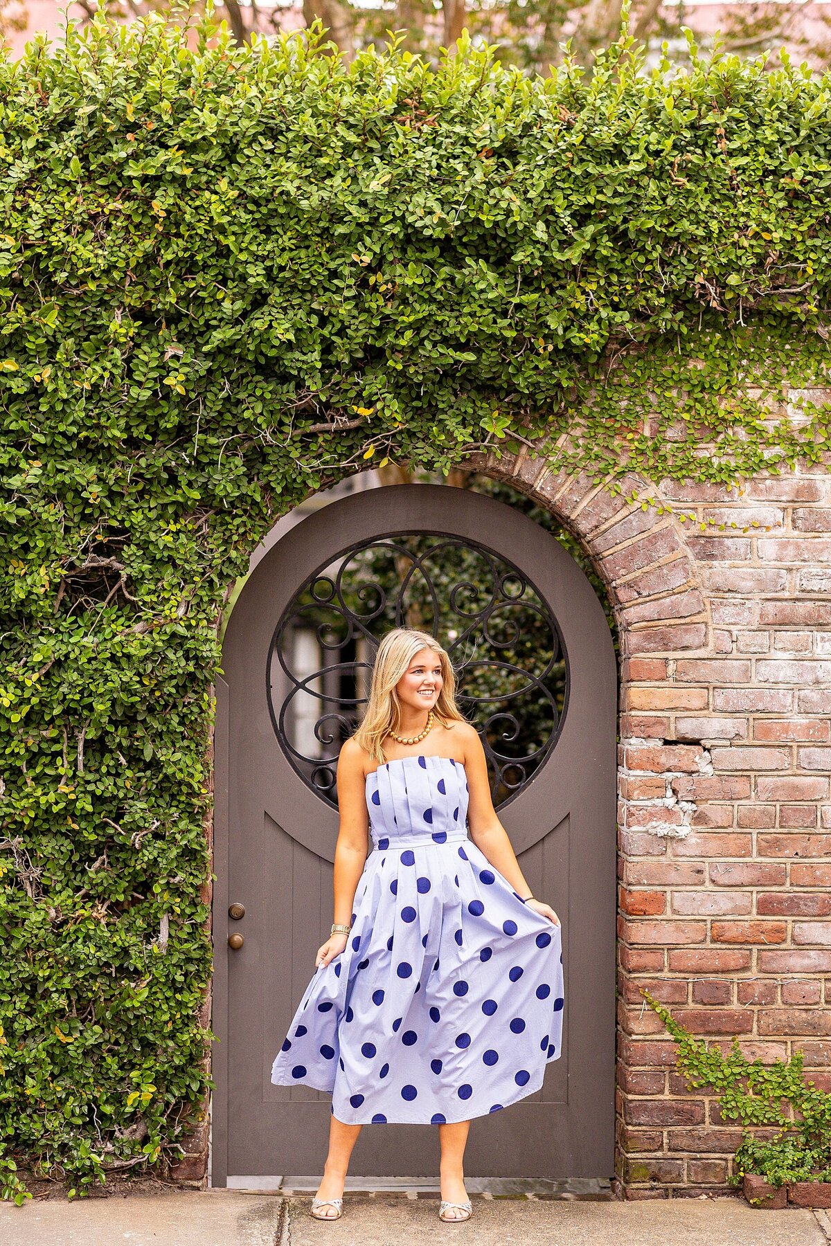Senior laughing and walking through downtown Charleston streets for personality-filled portraits