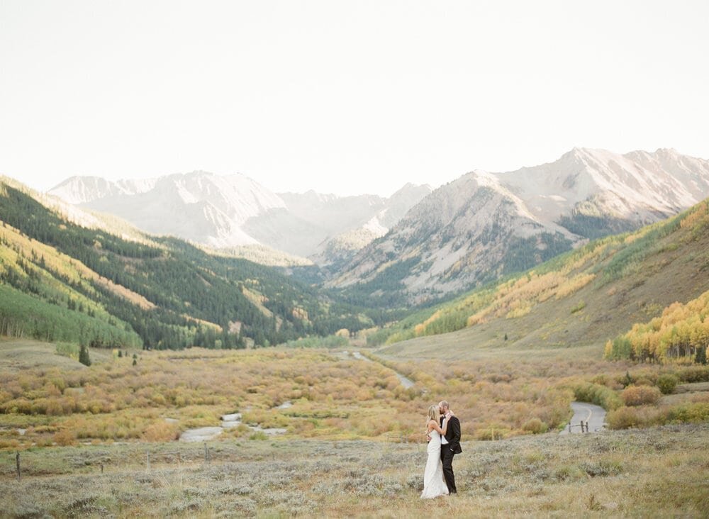 fine+art+photo+of+bride+and+groom+kissing+in+mountains+with+fall+foliage