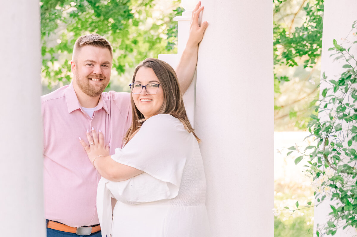 A happy couple embracing under a pavillion in Charlotte at sunset during their engagement session with JoLynn Photography, a destination wedding photographer